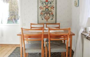 een eettafel met 4 stoelen en een schilderij bij Gorgeous Home In Enviken With Wifi in Enviken
