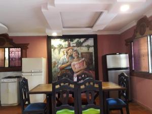 a kitchen with a table and a painting on the wall at Villa Imperio in La Fuente