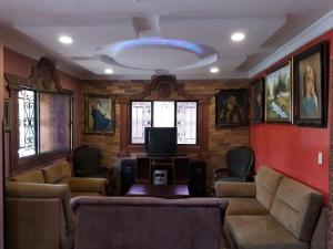 a living room with couches and a flat screen tv at Villa Imperio in La Fuente