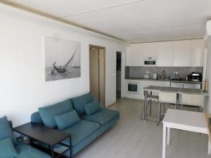 a living room with a blue couch and a kitchen at K&K Apartment Siófok in Siófok