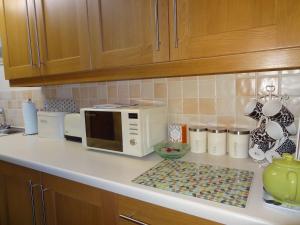 a kitchen counter with a microwave on a counter top at Birchwood House in Church Stretton