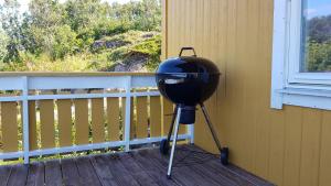 a grill sitting on a porch next to a window at Farmer Apartment in Laukvik