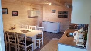 a small kitchen with a table and a refrigerator at Farmer Apartment in Laukvik