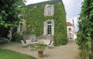 a building covered in ivy with chairs and a table at Cozy Home In Chablis With Wifi in Chablis