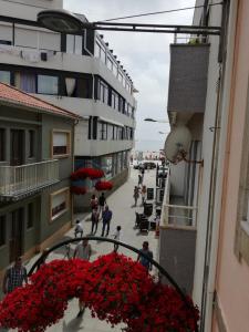 a view of a street with red flowers on a balcony at Baixinho Guest House in Vila Praia de Âncora