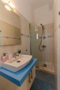 a bathroom with a white sink and a shower at Votsalo in Astypalaia