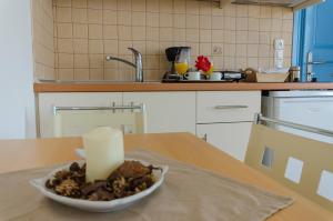 świeca w misce na stole w kuchni w obiekcie Votsalo w mieście Astypalea