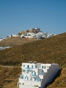 een wit gebouw op een heuvel met huizen bij Votsalo in Astypalaia-stad (Chora)