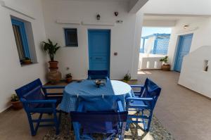 a dining room with a blue table and chairs at Votsalo in Astypalaia