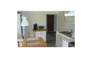a kitchen with a table and a dining room at Cozy Home In Katrineholm With Lake View in Katrineholm