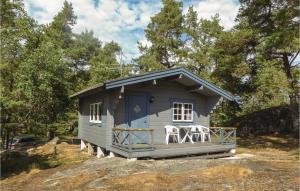 un pequeño cobertizo azul con 2 sillas en el porche en Beautiful Home In Trosa With House Sea View, en Trosa