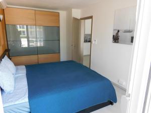 um quarto com uma cama azul e uma cabeceira em madeira em K&K Apartment Siófok em Siófok