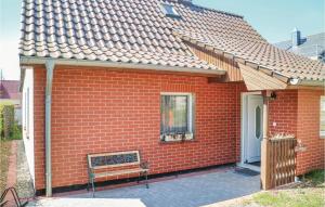 una casa de ladrillo rojo con un banco delante de ella en 2 Bedroom Awesome Home In Zingst, en Zingst