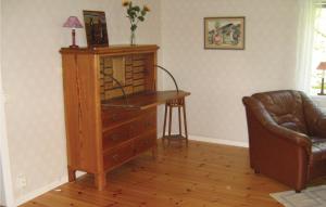 a living room with a wooden dresser and a chair at Two-Bedroom Holiday Home Skeppshult 02 in Skeppshult