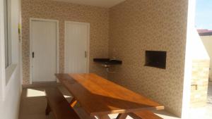 una mesa de madera en la esquina de una habitación en Casa temporada condomínio -ingleses Florianópolis-SC, en Florianópolis