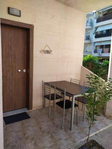 un tavolo e sedie seduti accanto a una porta di Ζ&Ζ Studios a Perea