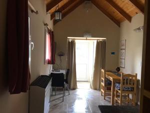 Habitación con cocina, mesa y ventana en Mono Ambiente Clarien en Lago Puelo