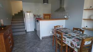 a kitchen with a table and chairs and a refrigerator at SEJOUR AU COEUR DES VOLCANS in Saint-Ours