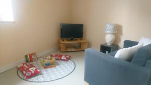 a living room with a blue couch and a tv at SEJOUR AU COEUR DES VOLCANS in Saint-Ours