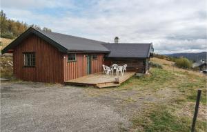eine Hütte mit einer Terrasse mit 2 Stühlen und einem Tisch in der Unterkunft Tallåsen Dagalifjell in Dagali