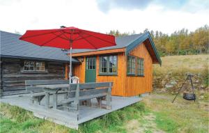 eine Holzhütte mit einem Picknicktisch und einem Sonnenschirm in der Unterkunft Tallåsen Dagalifjell in Dagali