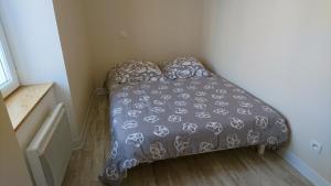 a small bedroom with a bed with a gray comforter at SEJOUR AU COEUR DES VOLCANS in Saint-Ours