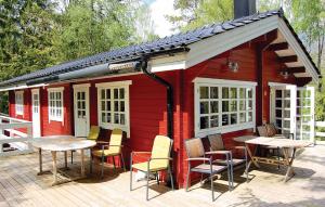 una cabina rossa con tavoli e sedie su una terrazza di 4 Bedroom Nice Home In Osby a Osby
