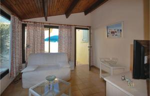 sala de estar con sofá blanco y TV en Cozy Apartment In Roquebrune Sur Argens With Outdoor Swimming Pool en Roquebrune-sur-Argens
