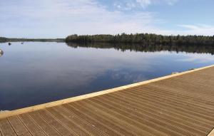 a view of a lake with a wooden dock at Cozy Home In Vittaryd With Sauna in Kvänarp