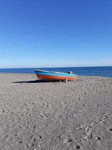 una barca seduta su una spiaggia sabbiosa vicino all'oceano di Belvedere a Policoro