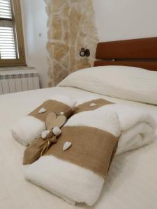 Una cama con una manta marrón y blanca. en Historical Domus, en Anagni