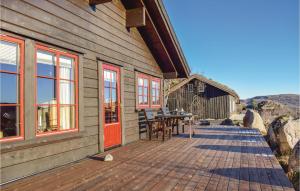 a wooden cabin with a table and chairs on a deck at Three-Bedroom Holiday Home In Aseral in Åseral