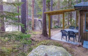 un cenador con mesa y sillas en el bosque en Amazing Home In Vittsj With Kitchenette en Visseltofta