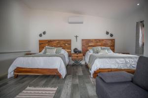 a bedroom with two beds and a couch at Villa San Juan Bed&Breakfast in Nuevo Vallarta