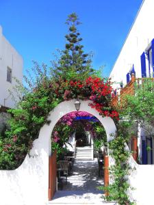 um arco com flores e uma árvore num edifício em Helliniko Hotel em Parikia