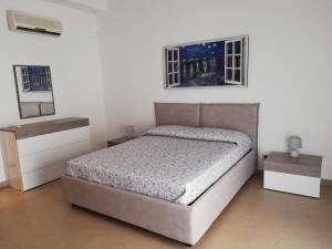 una camera con un letto e due finestre di Casa Lidia a Castellammare del Golfo