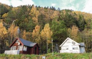 two houses are sitting in front of a mountain at 3 Bedroom Nice Home In Vallavik in Vangsbygd