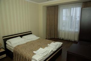 a bedroom with a bed with white sheets and a window at Hotel Deluxe in Horodenka +15 photos