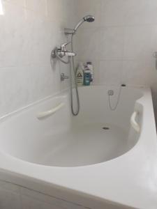 a bath tub with a shower head on top of it at Medjugorje Perfect family house in Međugorje +8 photos