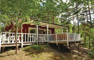une petite maison rouge dans les bois avec une terrasse couverte dans l'établissement Stunning Home In Yngsj With Wifi, à Yngsjö