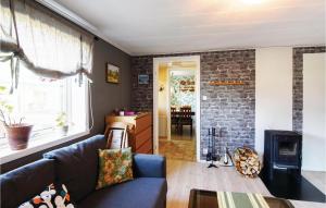 a living room with a blue couch and a brick wall at Beautiful Home In Väse With Kitchen in Ve