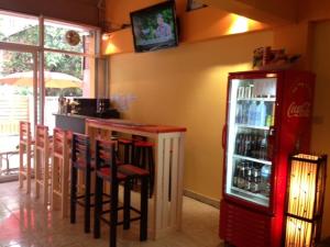 a restaurant with a bar with a soda refrigerator at Just Chill Inn in Chiang Mai