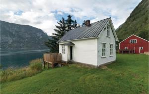 een wit huis en een rode schuur naast een lichaam water bij Naddvik in Naddvik