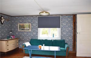 a living room with a green couch and a table at Awesome Home In Ryd With Kitchen in Ryd