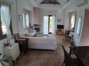a living room with a white bed and a couch at Evgenia Maisonette in Ierissos