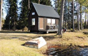a small cabin with a table and a boat in the grass at Lovely Home In Sandhem With Sauna in Sandhem