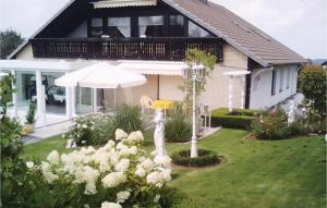 ein Haus mit einem Regenschirm und Blumen im Hof in der Unterkunft 2 Bedroom Nice Apartment In Bad Pyrmont in Bad Pyrmont