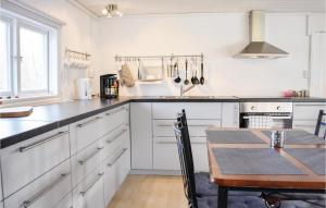 a kitchen with white cabinets and a wooden table at 2 Bedroom Gorgeous Home In Jämjö in JÃ¤mjÃ¶