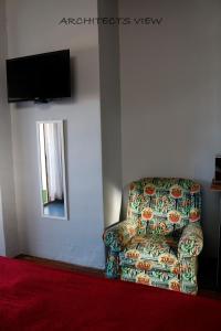 uma sala de estar com uma cadeira e uma televisão em ARCHITECT'S VIEW em Durban