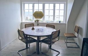 a table and chairs in a room with a window at Holiday Home Fiskarevägen Abbekås Ii in Abbekås +8 photos